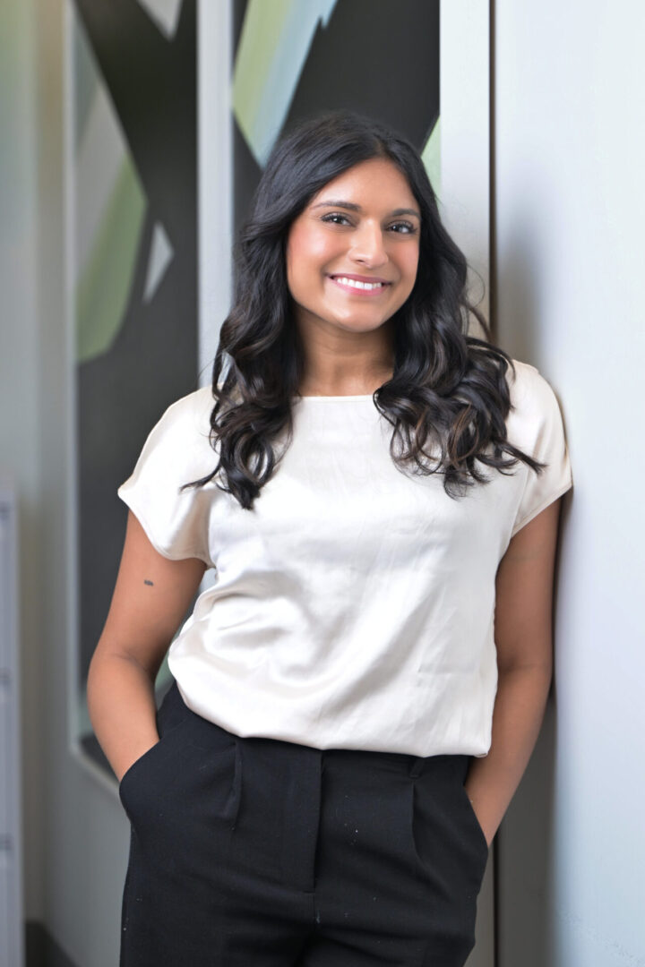 Smiling person in white shirt and pants.